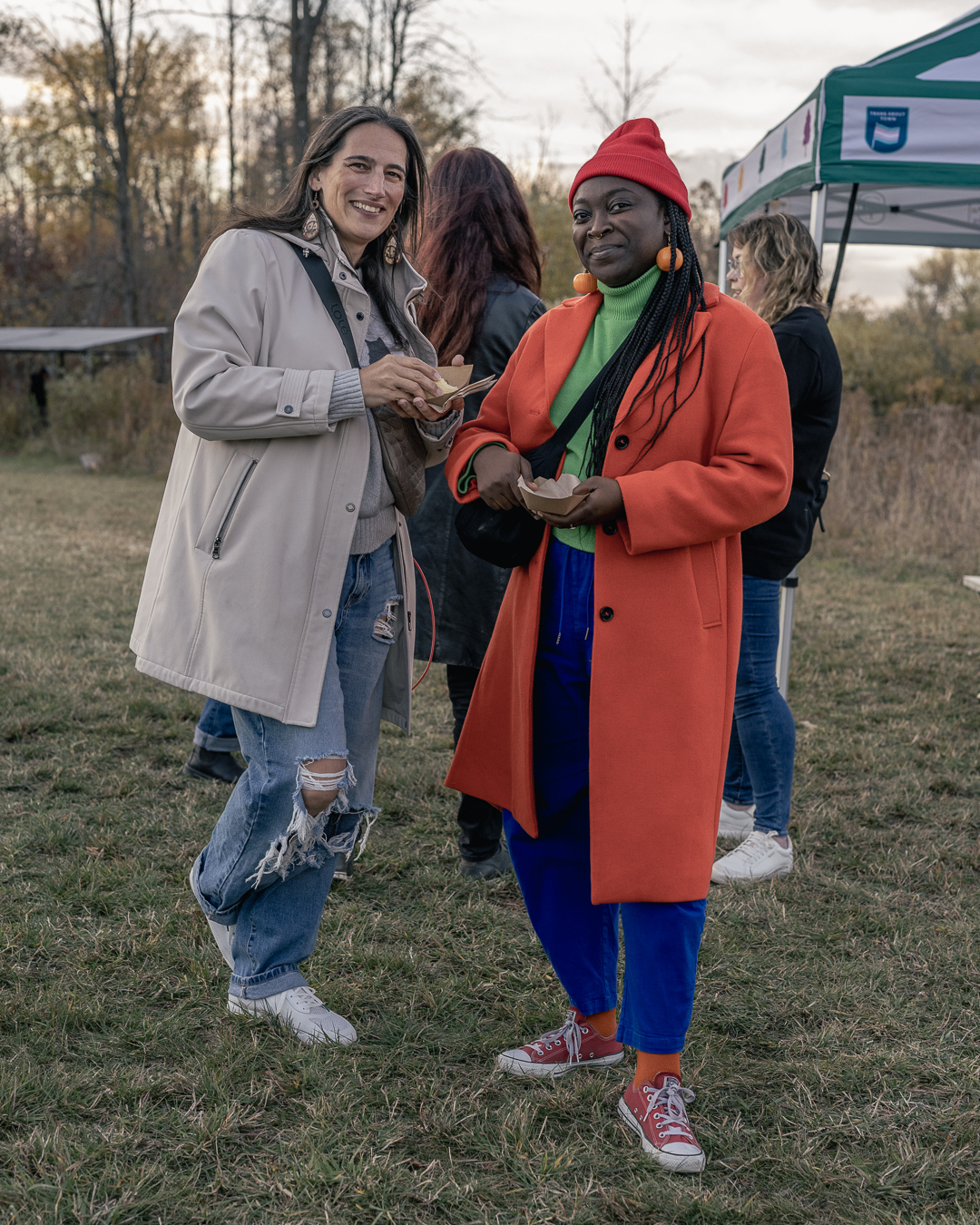 Two women posing at an Ottawa event while holding food, captured in a candid event photography moment.