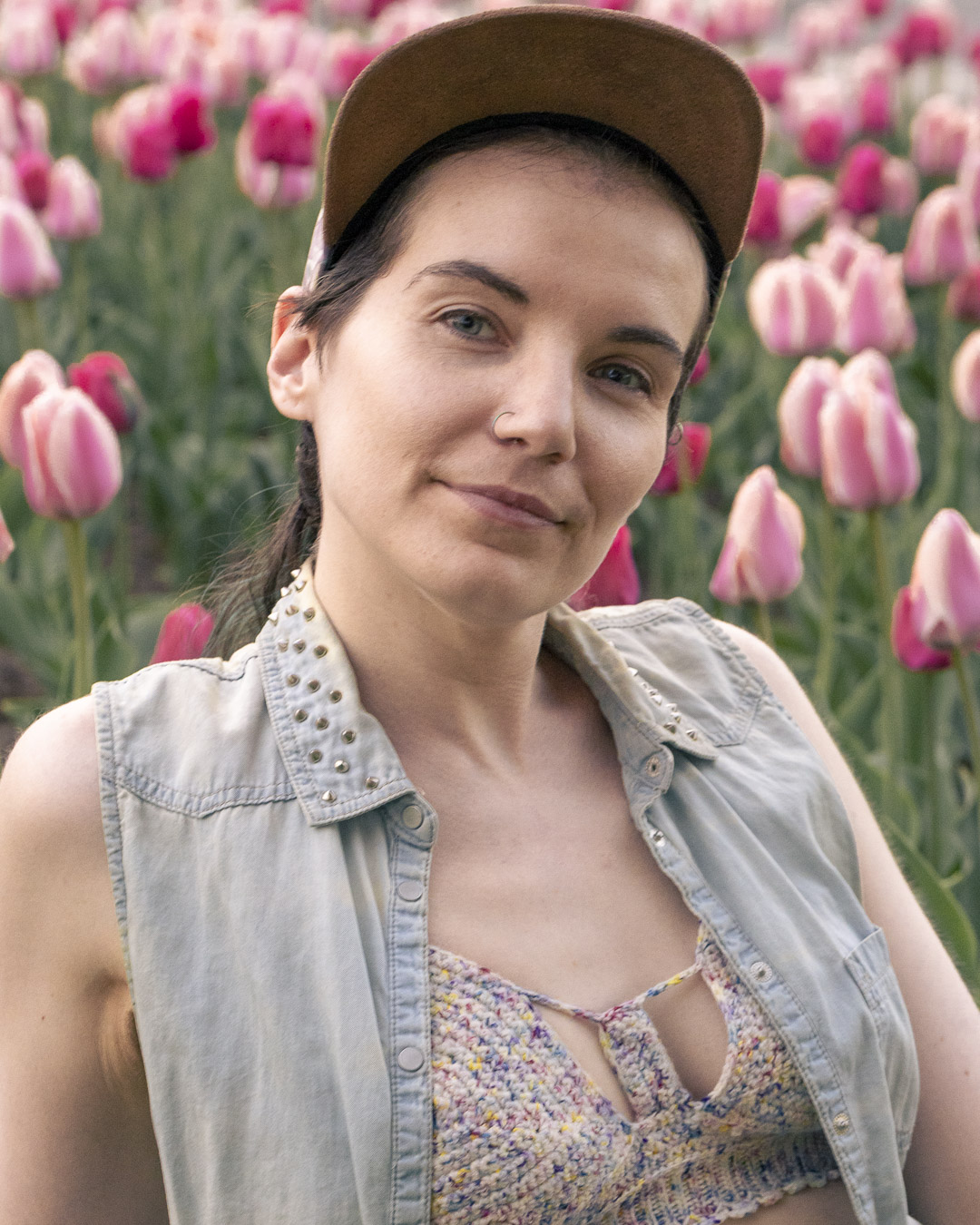 Person smiling during a headshot session with tulips in bloom at the Ottawa Tulip Festival.