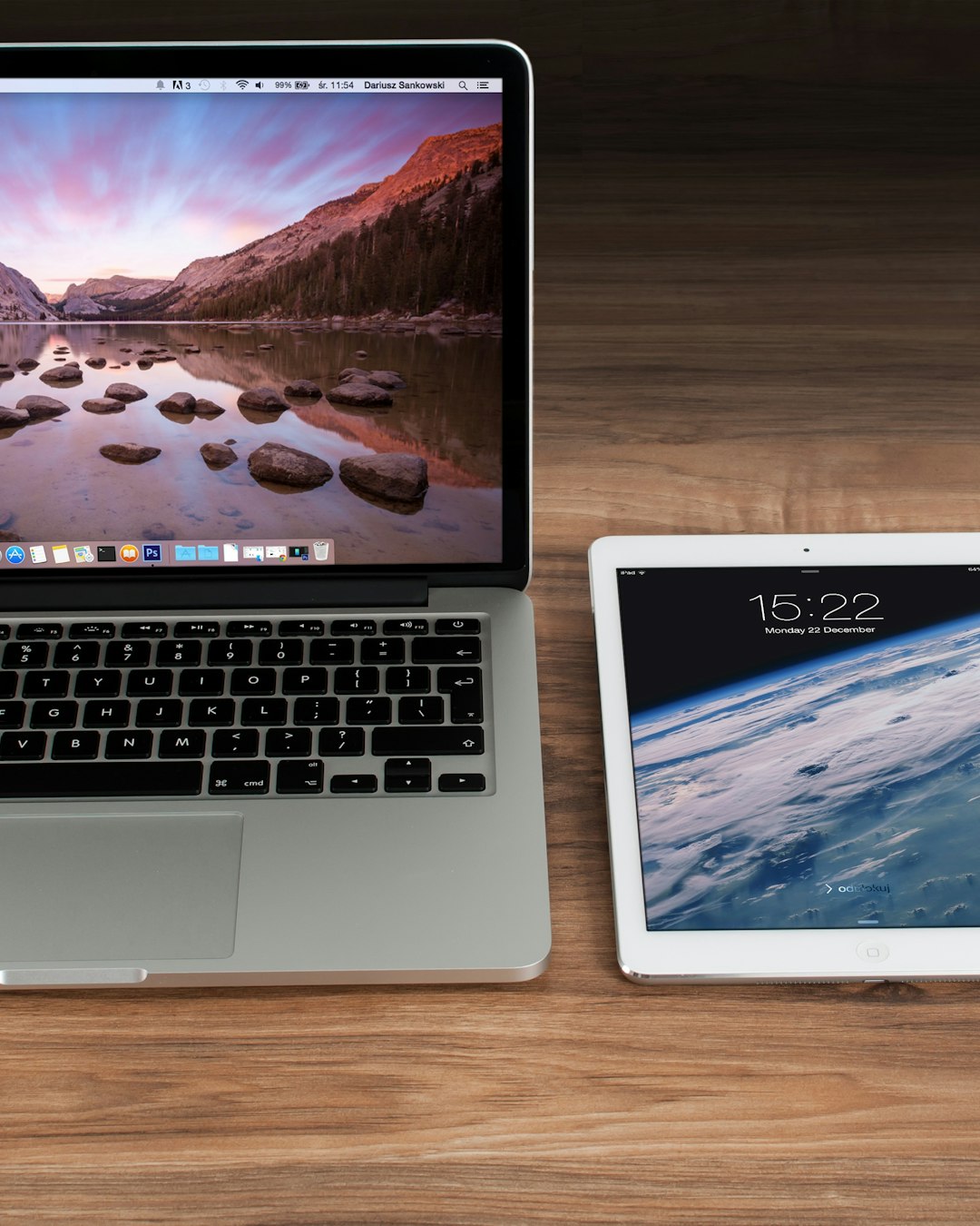 Laptop and tablet side by side on a wooden desk, representing responsive multi-device design